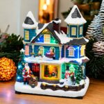 Casa con Babbo Natale con slitta in movimento a batteria 20xH23cm